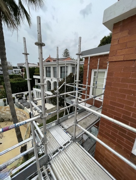 Residential Scaffolding Setup for Upper-Level Access Aluminium Scaffolding installed along the upper facade of a residential building near a coastal property.
